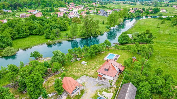 Ein ländliches Dorf mit Häusern, einem Fluss und einem Schwimmbad.