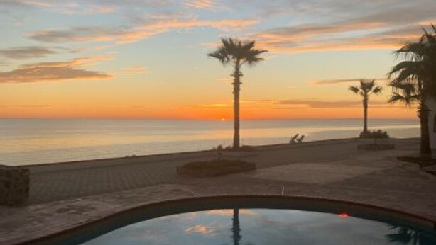 A swimming pool with a sunset view, palm trees, and a clear sky. - Villa 8 A Great Place to Relax and Create Great Memories! (Puerto Peñasco)