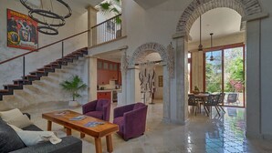 A spacious living area with a staircase, a dining area, and a view of the outdoors. - Luxury Casa Lourdes in Merida, Centro (Mérida)
