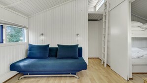 A room with a blue sofa, two wall-mounted lights, a window with blue shutters, and a bunk bed with white bedding. - Amazing home in Hampen with WiFi (Hampen)