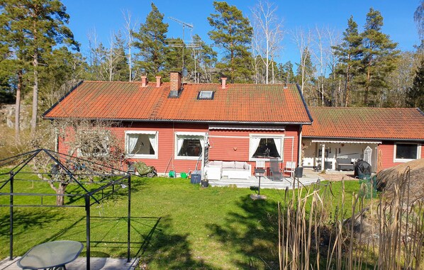 A red house with a sloped roof, a front porch, and a garage. - 4 bedroom nice home in Trosa (Trosa)
