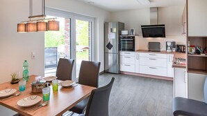 A modern kitchen with a dining area, stainless steel appliances, and a large window providing natural light. - Amazing home in Bleckede with WiFi (Bleckede)