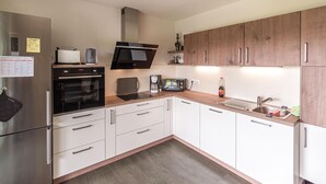 A compact kitchen with a stainless steel refrigerator, a built-in oven, a microwave, a coffee maker, and a toaster. - Amazing home in Bleckede with WiFi (Bleckede)
