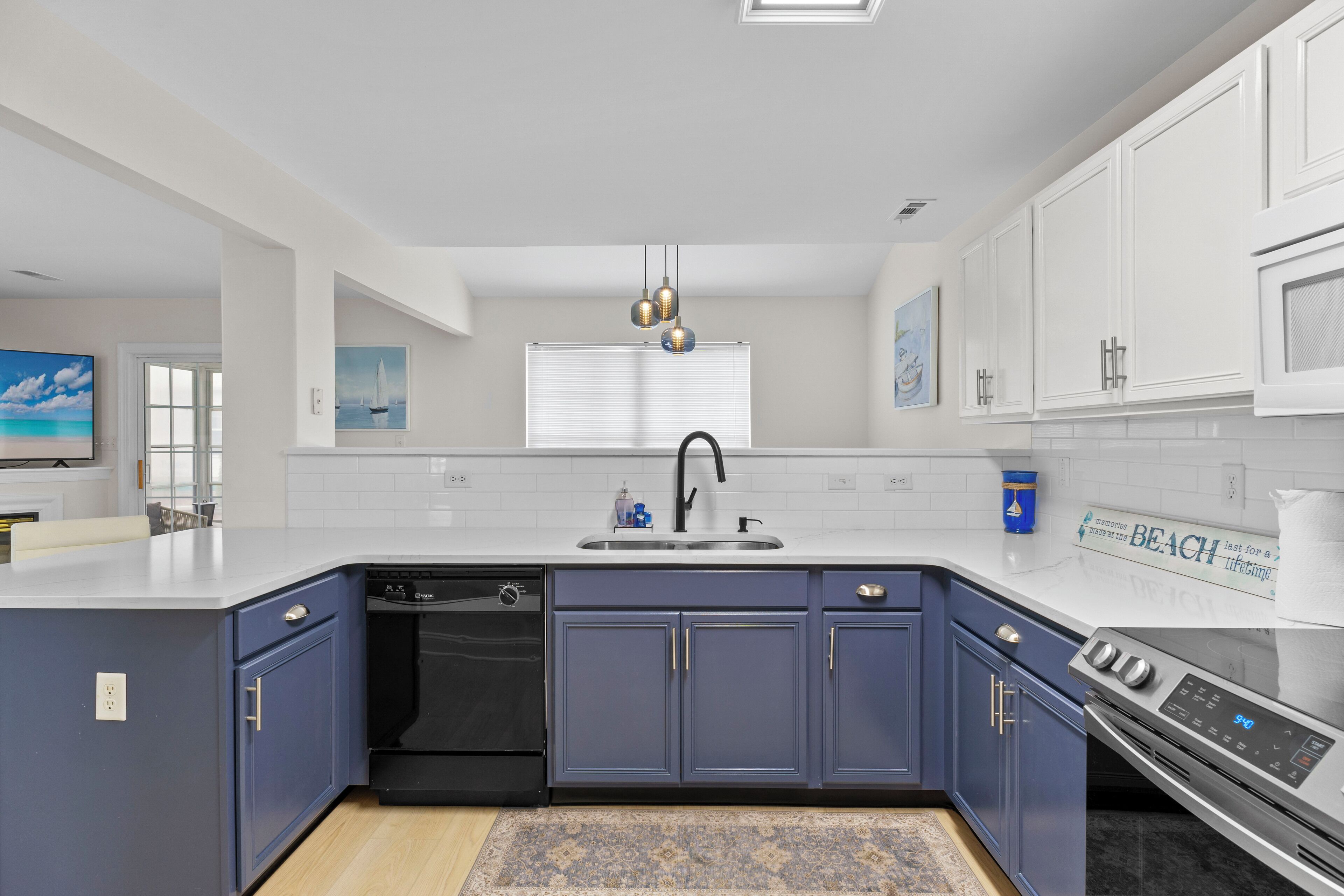 A modern kitchen with a built-in dishwasher, a stainless steel oven, and a large island with a sink.