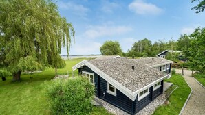 A two-story house with a gravel roof and a well-maintained lawn. - Stunning home in Skibby with WiFi (Skibby)
