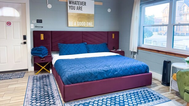 A bedroom with a large bed, a window with a view, a motivational quote on the wall, and a door with a no-smoking sign. - Luxe King Studio w/ Amazing View ~ Free Parking & WiFi (Memphis)