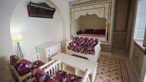 Ein Zimmer mit einem Bett, einem Schreibtisch, einem Stuhl und einer Lampe.