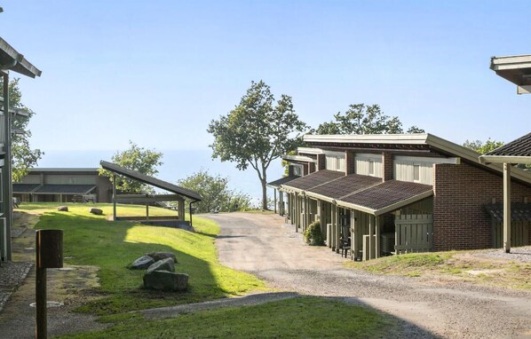 A row of single-story houses with a gravel driveway leading to a covered parking area. - Lovely apartment in Allinge with WiFi (Allinge)