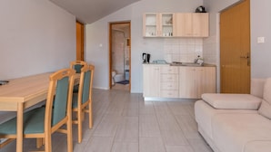 Een functionele ruimte met eethoek, kitchenette en een zithoek.