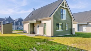 A modern single-story house with a gabled roof, a front porch, and a small attached garage. - Beautiful home in Büsum with sauna (Büsum)