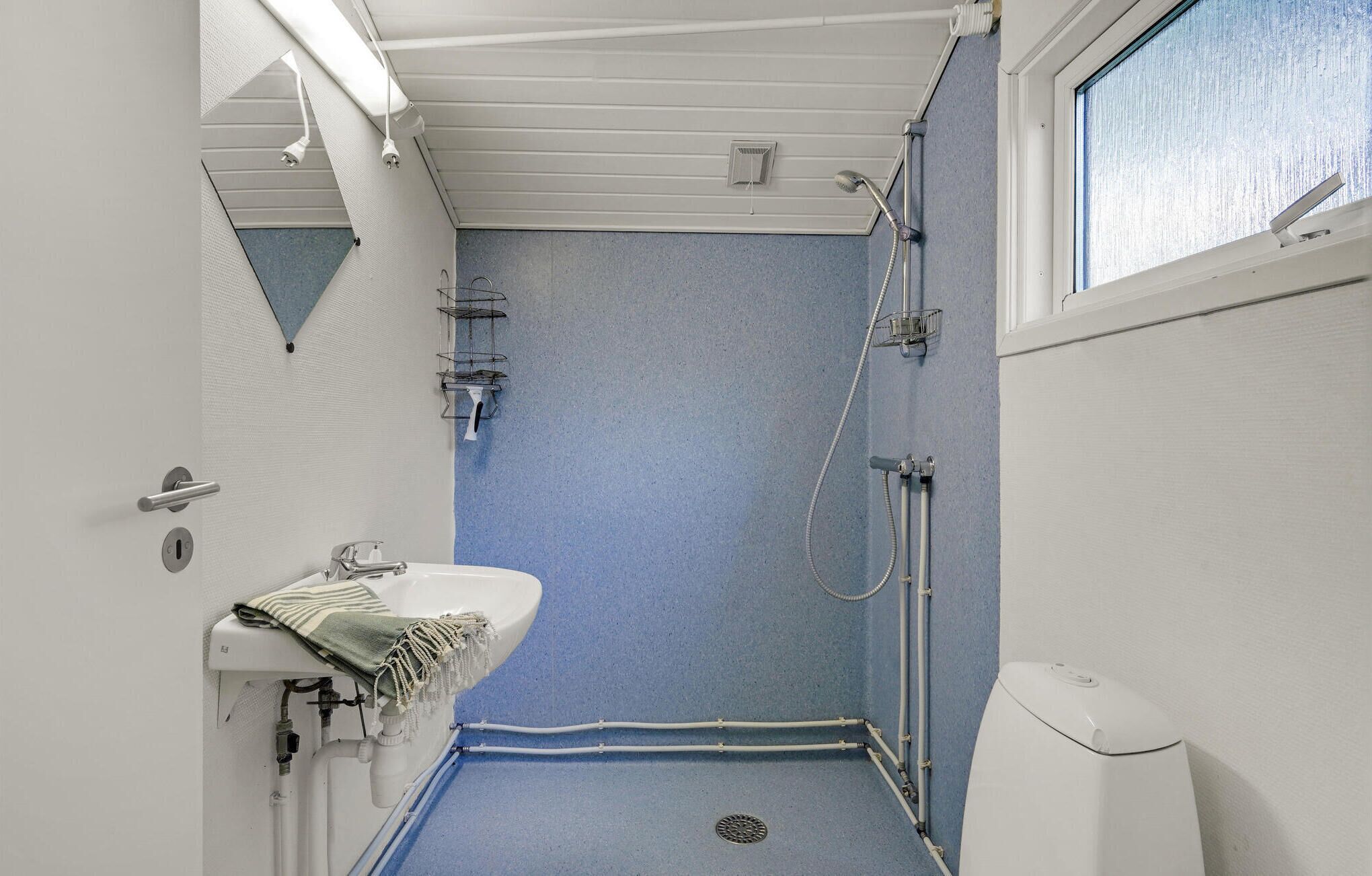 A bathroom with a shower, a sink, and a toilet.