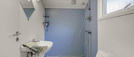 A bathroom with a shower, a sink, and a toilet.