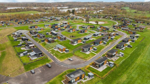 Un quartier résidentiel composé de maisons modernes disposées selon un plan en damier, caractérisé par de grandes fenêtres et des toits plats.