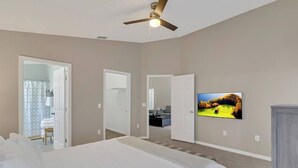 Ein Schlafzimmer mit einem großen Bett, einem Deckenventilator und einem Gemälde an der Wand.