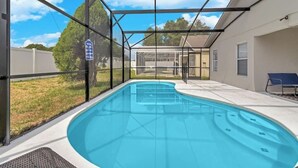 Ein Innenpool mit Glasveranda und einer Terrasse mit einem Stuhl.