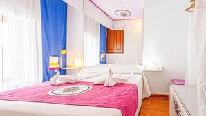 Una habitación de hotel con cama, mesita de noche, espejo y armario.