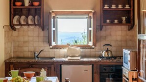 Cuina amb vistes per la finestra, un rentaplat, una cuina i armaris.