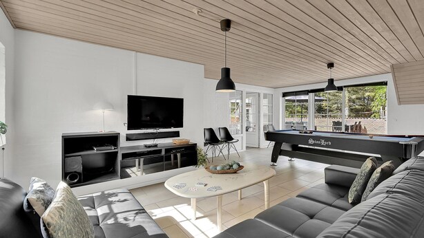A modern living room with a flat-screen TV, a pool table, and a sofa. - Gorgeous home in Ulfborg with kitchen (Ulfborg)