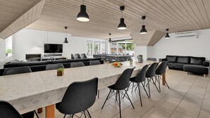 A spacious kitchen with a long dining table, black chairs, and pendant lights. - Gorgeous home in Ulfborg with kitchen (Ulfborg)