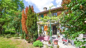 Una casa in pietra rustica con un giardino.