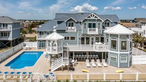 Una amplia casa con piscina, varias terrazas y zonas de estar al aire libre.