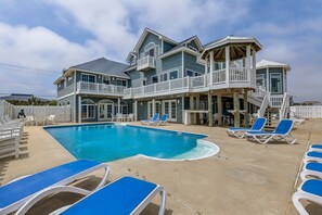A two-story house with a swimming pool, multiple balconies, and outdoor seating. - Sweetwater | Oceanfront | Private Outdoor Pool, Private Indoor Pool (Virginia Beach)