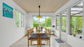 A dining area with a wooden table, chairs, and a yellow pendant light. - 2 bedroom nice home in Vordingborg (Vordingborg)
