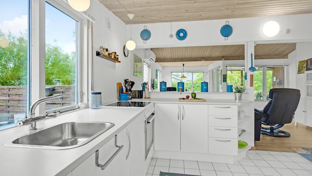 A modern kitchen with a large sink, white cabinets, and a view of greenery outside. - 2 bedroom nice home in Vordingborg (Vordingborg)