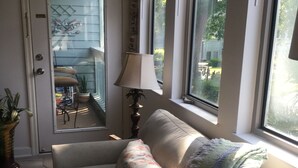 A cozy living room with a sofa, a lamp, and a view of the outside. - Myrtle Beach Resort Unit 6201 - Ocean Getaway (Myrtle Beach)