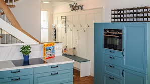 A kitchen with blue cabinets, a Novasol magazine, a 'Welcome' sign, and a wooden staircase. - 2 bedroom amazing apartment in Binz OT Prora (Binz OT Prora)