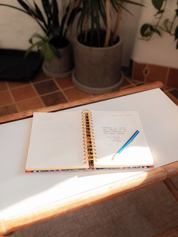 An open notebook with a date and a thank-you note on a wooden table.