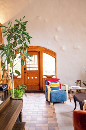 A cozy interior with a wooden door, a blue patterned chair, and a small table.