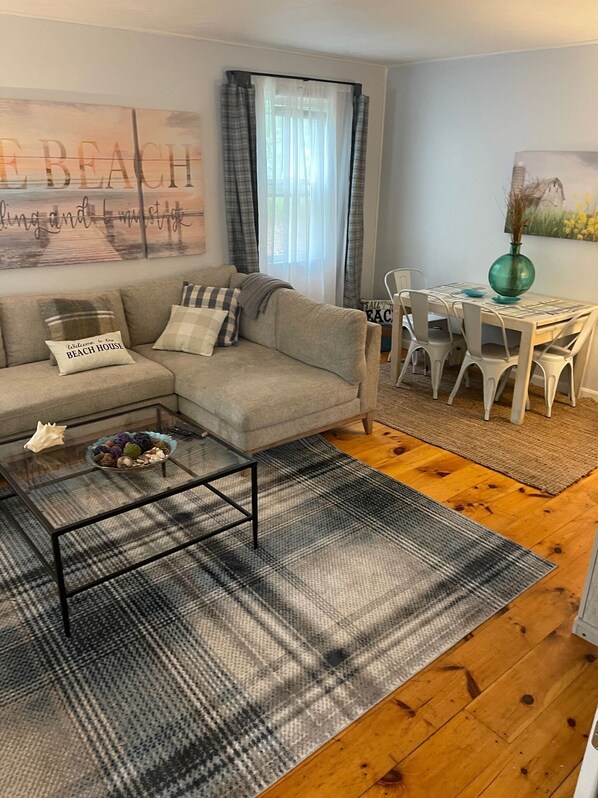 Ein Wohnzimmer mit Sofa, Couchtisch und Essbereich.