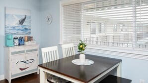 A dining area with a table, chairs, a coffee bar, and a window with blinds. - 300ft to the Beach • Central A/C, Linens & Towels, Beach Badges & Gear Included (Seaside Heights)