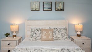 A bed with a white headboard, two nightstands with lamps, and three framed paintings on the wall. - 300ft to the Beach • Central A/C, Linens & Towels, Beach Badges & Gear Included (Seaside Heights)