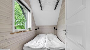 A narrow room with a bed, a window, and a door. - Cozy home in Gørlev with house sea view (Gørlev)