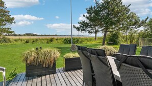 A deck with outdoor seating, a view of a grassy field, and a tree. - Cozy home in Gørlev with house sea view (Gørlev)