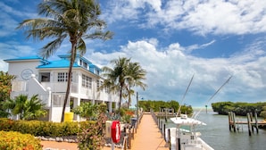 A waterfront hotel with a dock, palm trees, and a clear view of the water. - 🏝️OCEANFRONT PARADISE AWAITS YOU🏖️ (Tavernier)