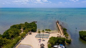 A beach with a wooden walkway, rows of beach chairs, and a small dock. - 🏝️OCEANFRONT PARADISE AWAITS YOU🏖️ (Tavernier)