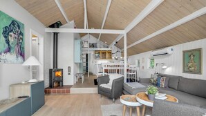 Een moderne woonkamer met een open haard, een eethoek en een keuken.