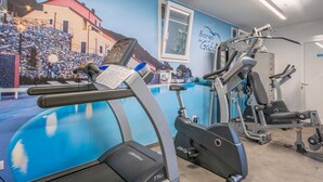Une salle de sport équipée de tapis de course, de vélos elliptiques et d’appareils de musculation.