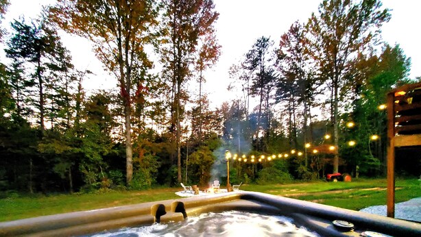 A hot tub surrounded by trees and a string of lights. - Three Bears Cabin - Unique Four Bedroom Luxury Cabin with Hot Tub! (Pickens)
