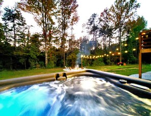 Ein Whirlpool, umgeben von Bäumen und einer Lichterkette.