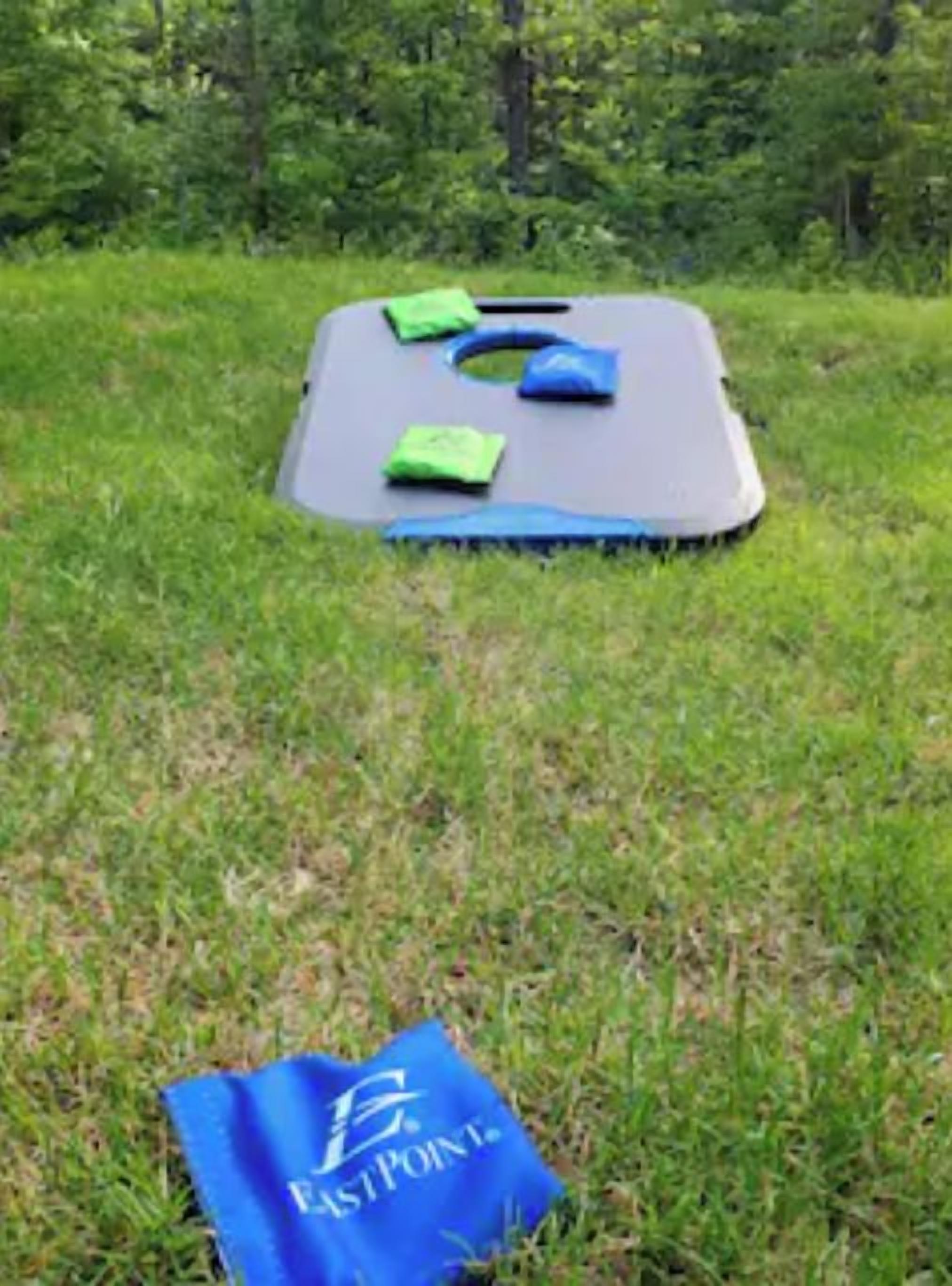A grassy area with a blue mat and a blue bag labeled "East Point."
