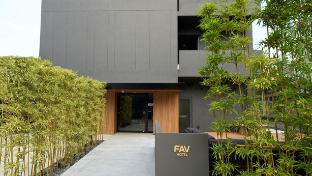 A modern hotel entrance with a pathway leading to the door, surrounded by bamboo plants. - fav HIROSHIMA STADIUM (Hiroshima)