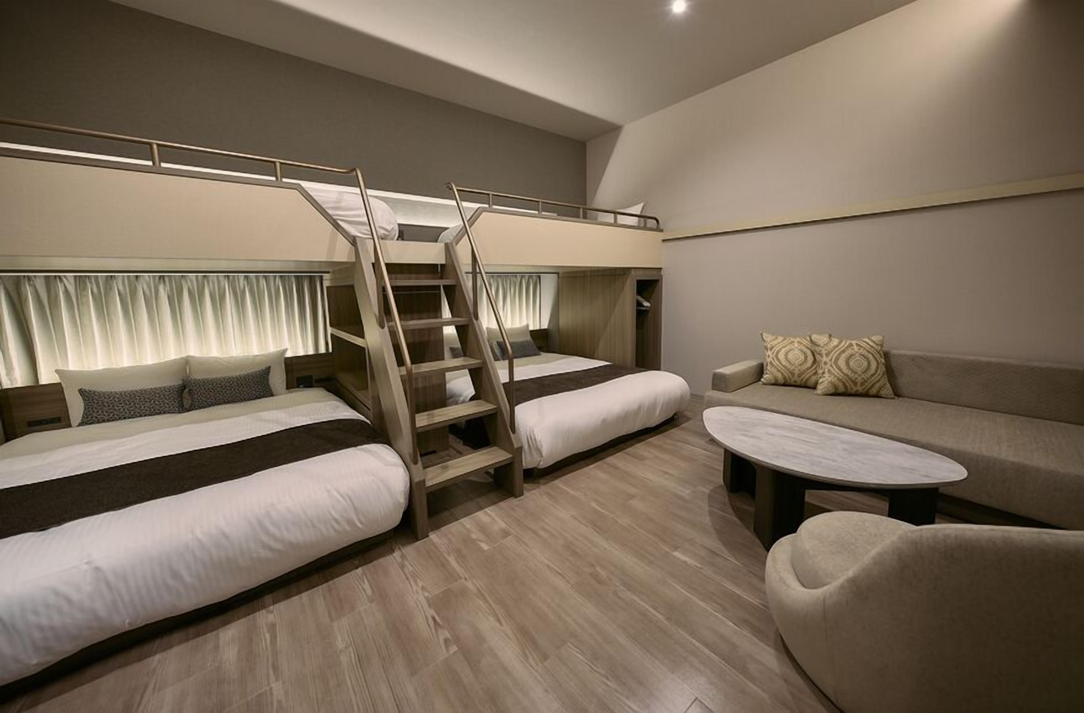 A room with bunk beds, a sofa, and a coffee table.