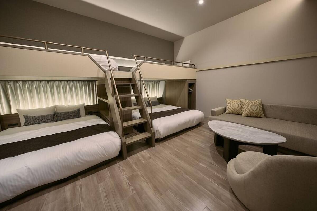 A room with bunk beds, a sofa, and a coffee table.
