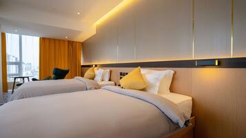 Een hotelkamer met twee bedden, een bureau en een stoel.