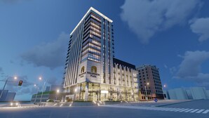 Ein Hochhaus mit einem markanten Schild mit der Aufschrift "Millennium Plaza", das eine moderne Glasfassade und mehrere Stockwerke aufweist.