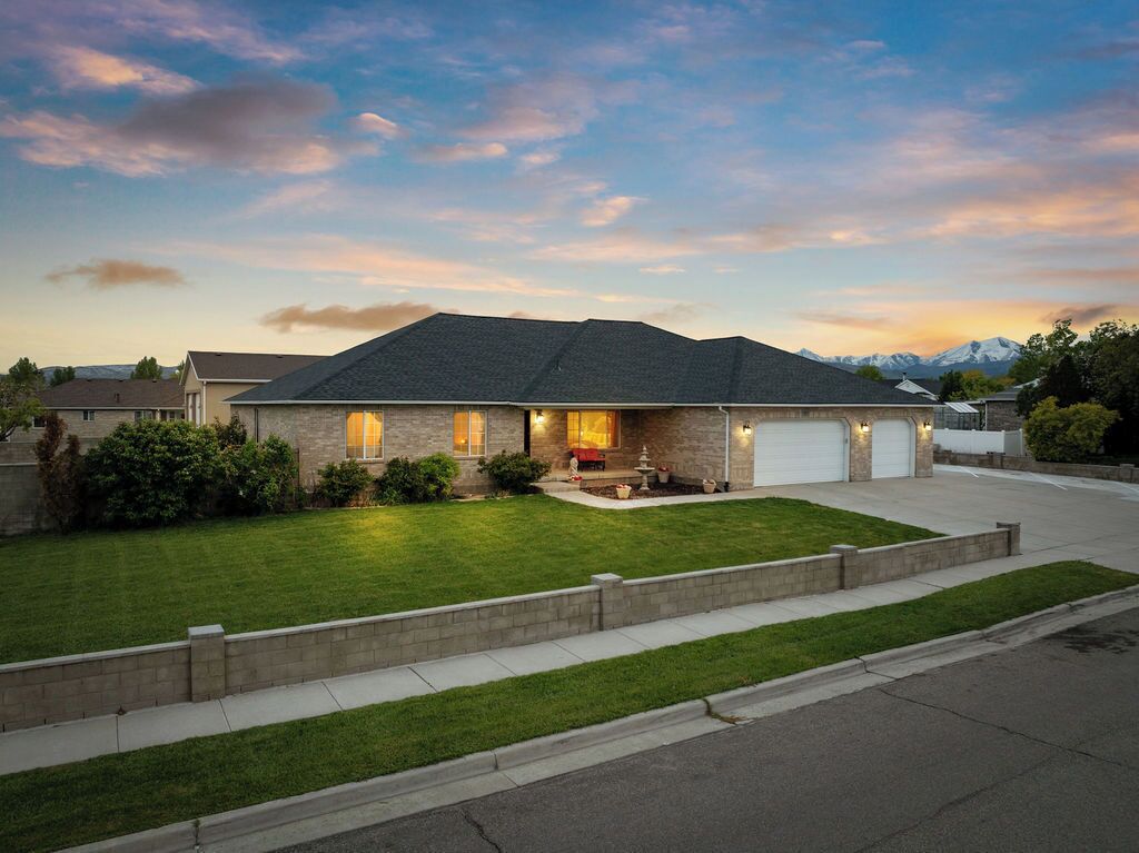A two-story house with a stone facade, a garage, and a well-maintained lawn.